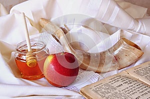 Rosh hashanah (jewesh holiday) concept - honey, apple and pomegranate over wooden table. traditional holiday symbols.