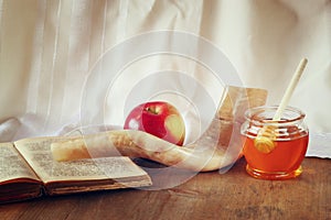 Rosh hashanah (jewesh holiday) concept - honey, apple and pomegranate over wooden table. traditional holiday symbols.