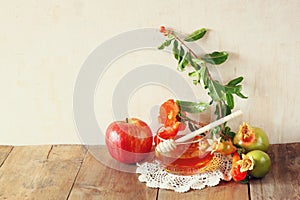 Rosh hashanah (jewesh holiday) concept - honey, apple and pomegranate over wooden table. traditional holiday symbols.