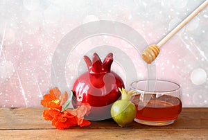 Rosh hashanah (jewesh holiday) concept - honey, apple and pomegranate over wooden table. traditional holiday symbols.