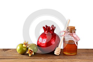 Rosh hashanah (jewesh holiday) concept - honey and pomegranate over wooden table. traditional holiday symbols.