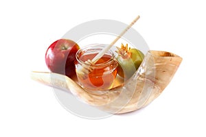 Rosh hashanah (jewesh holiday) concept - shofar (horn), honey, apple and pomegranate isolated on white. traditional holiday symbol