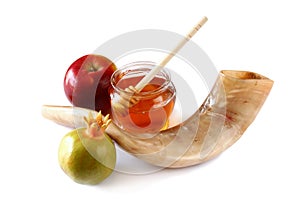 Rosh hashanah (jewesh holiday) concept - shofar (horn), honey, apple and pomegranate isolated on white. traditional holiday symbol