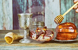 rosh hashanah jewesh holiday concept - shofar, torah book, honey, apple and pomegranate over wooden table