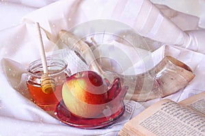 Rosh hashanah (jewesh holiday) concept - shofar, torah book, honey, apple and pomegranate over wooden table. traditional holiday