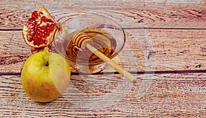 rosh hashanah jewesh holiday torah book, honey, apple and pomegranate over wooden table. traditional symbols.