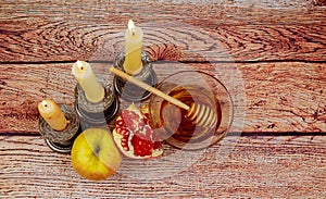rosh hashanah jewesh holiday torah book, honey, apple and pomegranate over wooden table. traditional symbols.
