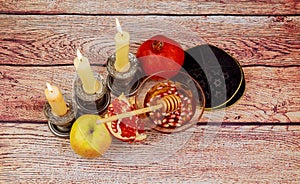 rosh hashanah jewesh holiday torah book, honey, apple and pomegranate over wooden table. traditional symbols.