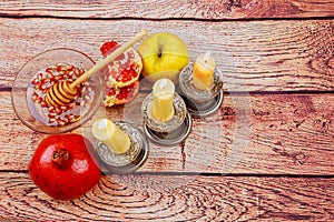 rosh hashanah jewesh holiday torah book, honey, apple and pomegranate over wooden table. traditional symbols.