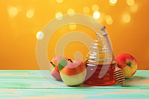 Rosh hashanah jewish new year holiday celebration concept. Honey and apples over yellow background