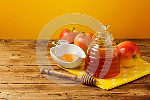 Rosh hashanah jewish new year holiday celebration concept. Honey and apples over yellow background