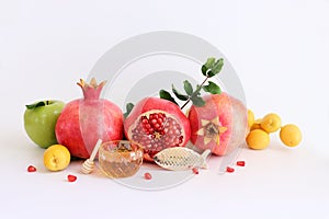 Rosh hashanah (jewish New Year holiday) concept. Pomegranate, apple and honey traditional symbols over white background