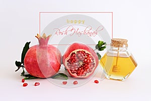 Rosh hashanah (jewish New Year holiday) concept. Pomegranate and honey traditional symbols over white background