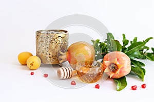 Rosh hashanah (jewish New Year holiday) concept. Pomegranate and honey traditional symbols over white background