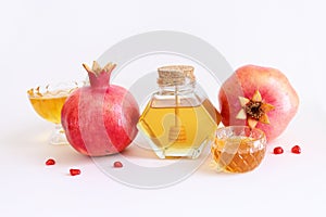 Rosh hashanah (jewish New Year holiday) concept. Pomegranate and honey traditional symbols over white background
