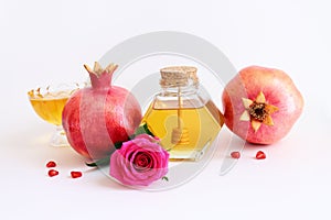 Rosh hashanah (jewish New Year holiday) concept. Pomegranate and honey traditional symbols over white background