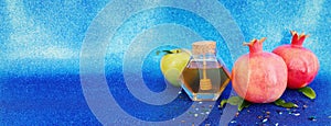 Rosh hashanah (jewish New Year holiday) concept. Taditional symbols over blue glitter background