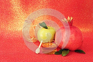 Rosh hashanah (jewish New Year holiday) concept. Taditional symbols over red glitter background