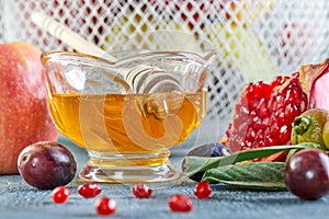 Rosh hashanah - jewish New Year holiday concept. Traditional symbols: Honey jar and fresh apples with pomegranate and basket with