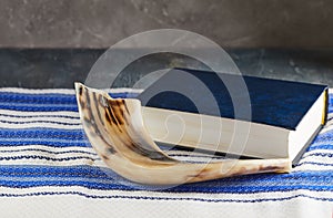 Rosh hashanah - jewish New Year holiday concept. Traditional symbols: Shofar - horn, tallite and Torah on a gray background