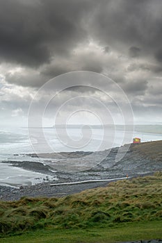 Rosses point beach in a mist, county Sligo, Ireland. Dark storm clouds over Atlantic ocean,