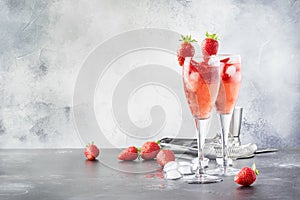 Rossini alcoholic cocktail with Italian sparkling wine, strawberry puree and ice in champagne glasses, place for text, selective