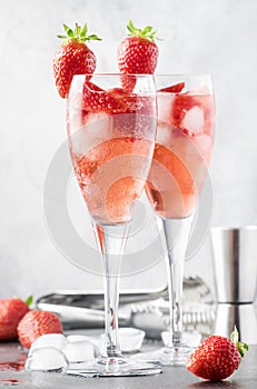 Rossini alcoholic cocktail with Italian sparkling wine, strawberry puree and ice in champagne glasses, place for text, selective