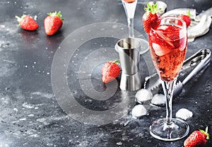 Rossini - italian alcoholic cocktail with sparkling wine, fresh strawberry puree and ice in champagne glasses, copy space,