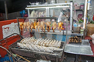 Rosted chicken and fish grilled at a movable market stall in Bangkok