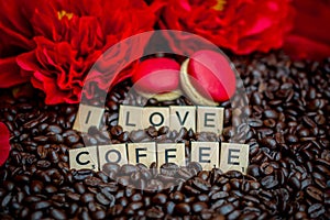 rosted coffee beans with red macaroon red flowers and letters I LOVE Coffee