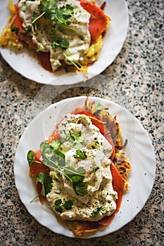 Rosti eggs royale. Potato pancakes with smoked salmon, poached eggs and hollandaise sauce, coriander.