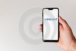 Minsk, Belarus- June 18 2020: smartphone with wirecard logo on the screen. hand touching the screen