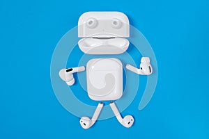 Rostov, Russia - July 06, 2020: Funny little man with arms, legs and eyes made of Apple wireless headphones and charging