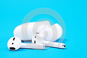 Rostov, Russia - July 06, 2020: Apple AirPods wireless Bluetooth headphones and charging case for Apple iPhone lie on a