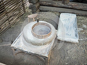 Rotary discoid mill stone for hand-grinding a grain into flour. Medieval hand-driven millstone grinding wheat. The