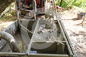 Rotary drilling rig at a construction site.Sludge flow from the joule during the water well drilling