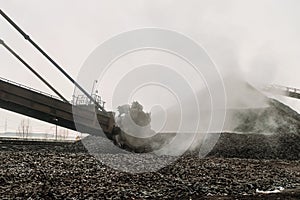 Rotary excavator digs and loads the hot briquetted iron