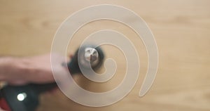 Rotating drill, close-up, on the background of a wooden tabletop. Top view, blurry. Demonstration of the operation of an