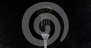 Rotating fork with cabbage on black background