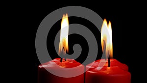 Rotating four red candles burning fire slowly spinning on a black background