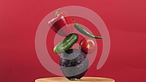 rotating fresh vegetables on a red background. Creative food concept. Equilibrium floating food balance.