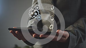 Rotating gears above an electronic tablet in the hands of a businesswoman. CG