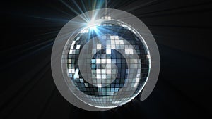 Rotating and glowing disco ball on black background