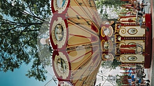 Rotating High Speed Carousel Merry-Go-Round In City Amusement Park. Attraction Ferris Wheel On Summer Evening In City