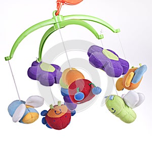 Rotating mobile with soft toys on a childÂ´s bed