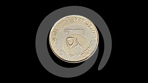 Rotating obverse of United Arab Emirates coin 25 fils. Isolated in black background.