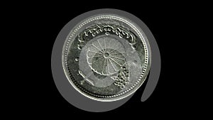 Rotating reverse of Japan coin 10 sen minted from 1940 till 1943 with inscription meaning TEN SENS. Isolated in black background.