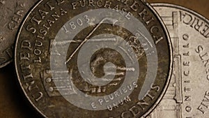 Rotating stock footage shot of American nickles (coin - $0.05)