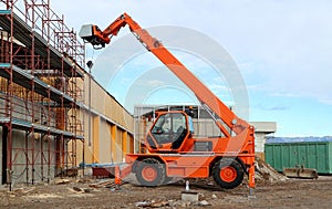 Rotating telehandler at work in an industrial  redevelopment area.