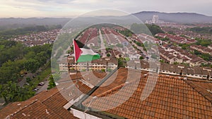 Rotating view of the national flag of Palestine waving above the building.